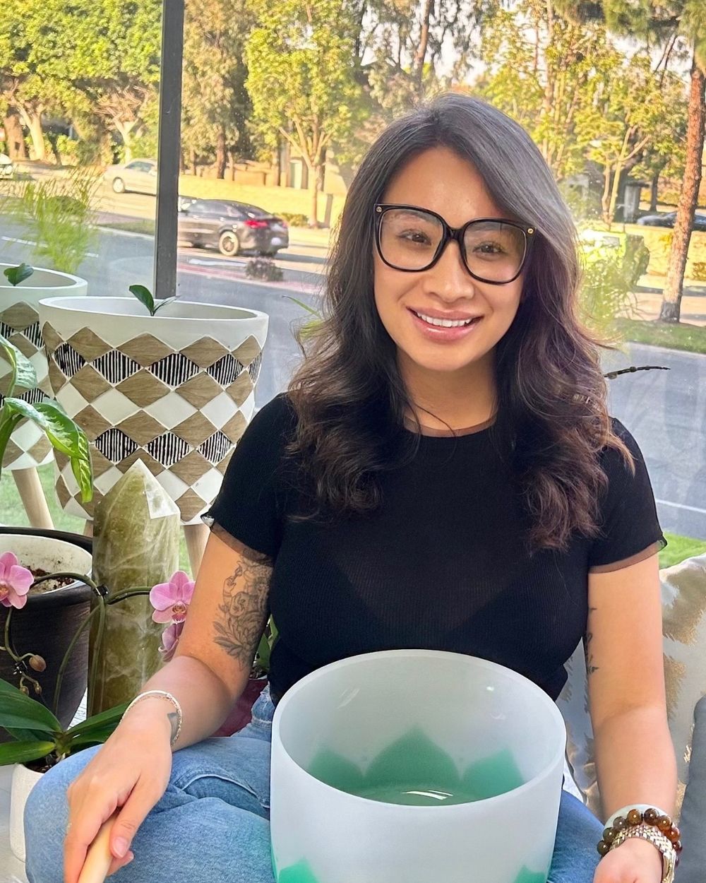 Nicky Pham seated with a crystal singing bowl at The Self-Love Healing Sanctuary
